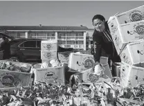  ??  ?? Volunteer Jennifer Rangel moves cabbages for distributi­on Friday at Gustafson Stadium.