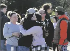 ?? BETH SCHLANKER/THE PRESS DEMOCRAT VIA AP ?? CAMERON GONZALEZ, 15, hugs fellow student Izzy Sullivan 18, while Cameron’s mom, Amy Gonzalez, stands nearby after students were released from the football field following a fatal stabbing at Montgomery High School on Wednesday in Santa Rosa, Calif.
