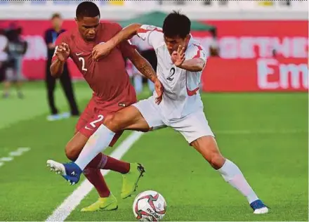  ?? AFP PIC ?? Qatar’s Pedro Miguel Correia (left) fights for the ball with North Korea’s Chol Bom Kim in their Asian Cup Group E match at Khalifa bin Zayed Stadium yesterday.