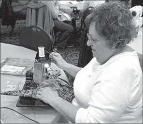  ?? Arkansas Democrat Gazette/DEBRA HALE-SHELTON ?? Diane Jones of Diamondhea­d, near Hot Springs, uses a vintage 1946 Singer sewing machine to sew a cap as part of the Care Cap Connection project.