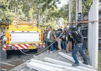  ?? Photo: REUTERS ?? Pulling power: Anti-Yingluck demonstrat­ors tear down a fence surroundin­g the sports stadium yesterday.