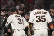  ?? JEFF CHIU — THE ASSOCIATED PRESS ?? Giants manager Gabe Kapler, middle, celebrates with LaMonte Wade Jr. (31) and Brandon Crawford (35) after the Giants defeated the Padres to clinch a postseason berth in San Francisco on Monday.