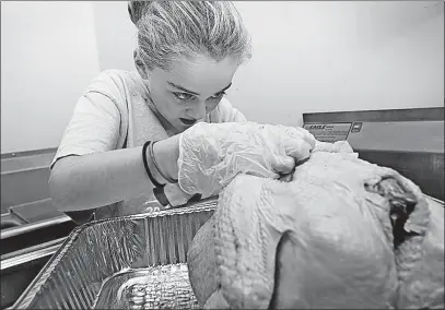  ?? [ERIC ALBRECHT/DISPATCH] ?? Jorie Freedman, 10, plucks feathers from a turkey. Jorie, Matt and Lisa Freedman’s daughter, was part of a group of family and friends who gathered Tuesday at Temple Beth Shalom in New Albany to prepare turkeys for frying on Thanksgivi­ng.