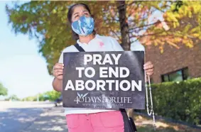  ?? LM OTERO/AP ?? Maria Peña holds a rosary and sign out outside a building housing an abortion provider in Dallas on Thursday.