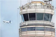  ?? CLIFF OWEN/AP ?? A passenger jet flies past the FAA control tower at Washington's Ronald Reagan National Airport. Air traffic control systems are one possible target of cyberterro­rists, experts say.