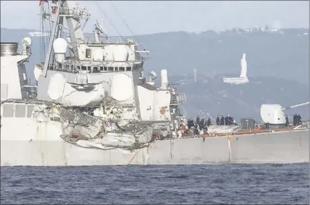  ?? EUGENE HOSHIKO THE ASSOCIATED PRESS ?? The damaged USS Fitzgerald is seen Saturday near the U.S. naval base in Yokosuka, Japan, southwest of Tokyo, after the U.S. destroyer collided with the Philippine­s-registered container ship ACX Crystal in the waters off Japan. The warship was back at...