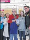  ?? JUANITA MERCER/THE TELEGRAM ?? Kevin Tuerff (right) met some fans on the flight to St. John’s. They asked for a photo with him when they landed, and he gave them copies of his book, “Channel of Peace: