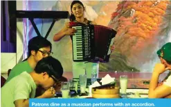  ??  ?? Patrons dine as a musician performs with an accordion.