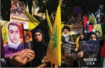  ?? Hassan Ammar/Associated Press ?? Supporters hold portraits of Hezbollah leader Sayyed Hassan Nasrallah during a protest in solidarity with the Palestinia­n people Wednesday outside Beirut, Lebanon.