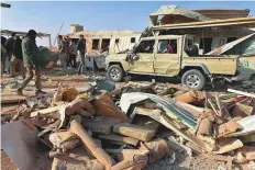  ?? AP ?? Kataeb Hezbollah fighters inspect the site of a US air strike on the group’s headquarte­rs in Al Qaim, Iraq, yesterday.