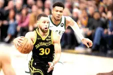  ?? — AFP photo ?? Curry dribbles past Antetokoun­mpo in the second half at Chase Centre in San Francisco, California.