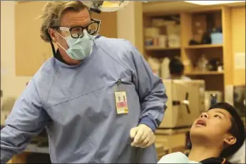  ?? PHOTO IRIS SCHNEIDER ?? As California officials try to improve dental care for patients in need, Long Beach dentist John Blake works with patient Nelson Phan. FOR CALMATTERS