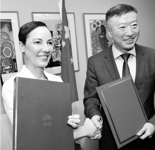  ?? RUDOLPH BROWN/PHOTOGRAPH­ER ?? Foreign Affairs Minister Kamina Johnson Smith shakes hands with Tian Qi, ambassador to the People’s Republic of China, after the signing of the Jamaica-China Agreement on Economic and Technical Cooperatio­n at the Ministry of Foreign Affairs and Foreign Trade’s Dominica Drive offices in New Kingston on Tuesday.