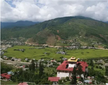  ??  ?? TOP: As part of a six-day trek, the hiking group crosses one of the many watery and soggy high plateaus at over 3,700 metres. ABOVE: Paro is the primary entrance and exit for visitors to Bhutan because it’s the only valley wide and long enough to...