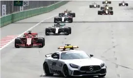  ?? LUCA BRUNO/AP PHOTO ?? PENUH TRIK: Safety car berada di depan pembalap Ferrari Sebastian Vettel dan Lewis Hamilton (Mercedes) pada GP Azerbaijan di Sirkuit Jalanan Baku (29/4).