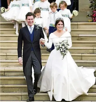  ??  ?? Nach der Trauung schreitet das Brautpaar aus der Kapelle und zeigt sich den Schaulusti­gen. Foto: WPA/Getty