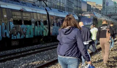  ??  ?? Lungo i binari
Alcuni passeggeri costretti a piedi per arrivare in stazione