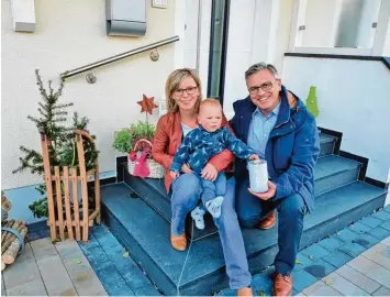  ?? Foto: Zita Schmid ?? Die Familie Baur nimmt heuer zum ersten Mal an der Adventsfen­steraktion teil. Kai Uwe Baur hält das Kerzenglas in der Hand, das in ihrem Fenster stehen wird. Auf dem Schoß von Andrea Baur sitzt ihr kleiner Sohn Matteo.