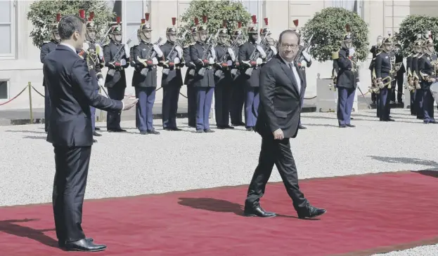  ?? PICTURES: THIERRY CHESNOT/GETTY IMAGES ?? 0 Emmanuel Macron gestures to outgoing president François Hollande as he leaves the palace at the end of the handover ceremony