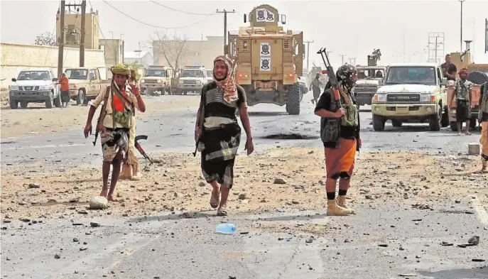  ??  ?? Combatient­es yemeníes proguberna­mentales, aliados de Arabia Saudí, se concentran en un barrio del este de Hodeida