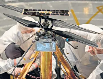  ??  ?? The Nasa team in the flight simulator with the model (main image) and how the helicoper could look on Mars