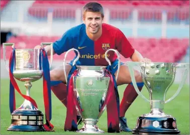  ?? ?? Piqué se fotografía con el triplete de la temporada 2008-09.