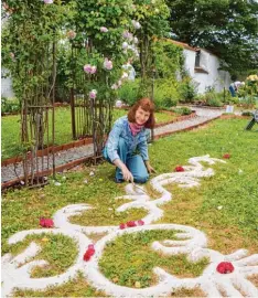  ??  ?? Mila Langbehn gestaltete im Garten des Rosenschlo­sses an Pfingsten sogenannte Ra sentattoos. Diese verschwind­en mit der Zeit in der Erde.
