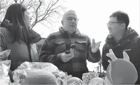  ?? PROVIDED TO CHINA DAILY ?? Klaus-Dieter Merz (center) from Germany talks with pedestrian­s on a canal river culture street, in Gucheng county, Hengshui, Hebei province.