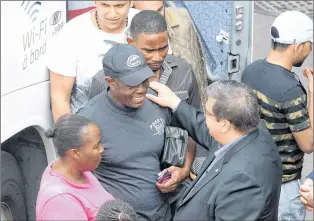  ?? CP PHOTO ?? Montreal mayor Denis Coderre, bottom right, greets newly-arrived asylum seekers at a reception area at the Olympic Stadium, in Montreal on Thursday.