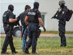  ?? Foto: Boris Roessler, dpa ?? Schwer bewaffnete Polizisten bringen Ali B. zum Verhör. Der 20 Jährige trägt Hand und Fußfesseln.