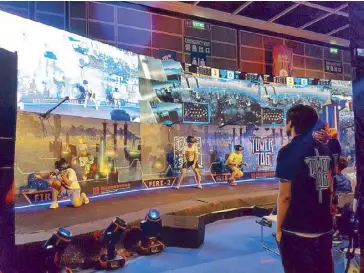  ??  ?? Visitors at the eSports and Music Festival try a virtual reality game (above left). The crowd cheers for the ZOTAC Cup champions (above right).