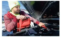  ??  ?? Jay Arias, owner Jays Towing, jumps a 2013 Jeep Wrangler at a residence in Shorewood on Tuesday. The recent extreme cold snap has been both a challenge and a boon for workers like landscaper­s, roadside mechanics and others who are forced to work...