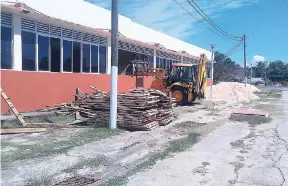  ?? PHOTO BY RACHID PARCHMENT ?? A backhoe dumps marl inside the area where new research centre will be built at the G.C. Foster College of Physical Education and Sport.