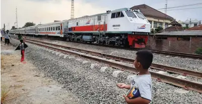  ?? RIZAL AMRULLOH ?? TAMBAH PERJALANAN: Kereta api melanjutka­n perjalanan setelah berhenti di Stasiun KA Mojokerto.