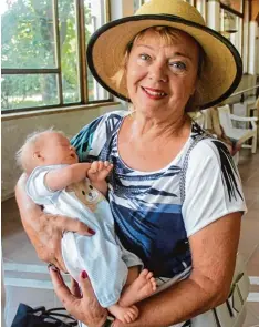  ??  ?? Echt ist auf diesem Foto nur Mary Ann Oteman aus München. Auf dem Arm hat sie eine täuschend echt aussehende Puppe.