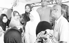  ??  ?? Hamisa (center) talking with Kampung Tanjong Batu villagers.