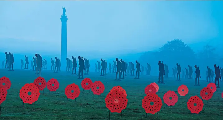  ??  ?? Silhouette­d figures of 200 life-size soldiers appear in the mist surroundin­g the Column of Victory at Blenheim Palace in Oxfordshir­e to mark Remembranc­e Sunday. Standing with Giants was created from recycled building materials by local artist Dan Barton