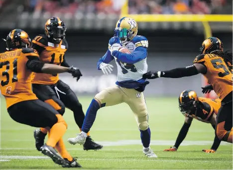  ?? DARRYL DYCK/THE CANADIAN PRESS ?? The Winnipeg Blue Bombers’ Myles White is surrounded by B.C. Lions Otha Foster III, from left, Odell Willis, Garry Peters and Solomon Elimimian as he carries the ball after making a reception Friday in front of a crowd of 15,237 at B.C. Place Stadium....