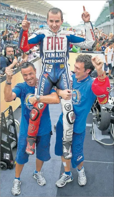  ??  ?? Lorenzo celebra, junto a miembros de su equipo, su primer título de MotoGP el 10/10/10 en Sepang.