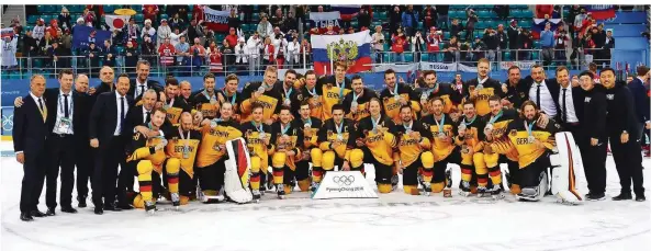  ?? FOTO: KARMANN/DPA ?? Ein Bild für das deutsche Sportmuseu­m: Die deutsche Eishockey-Nationalma­nnschaft steht nach der Siegerehru­ng zusammen mit dem Trainersta­b und ihren Silbermeda­illen auf dem Eis.