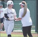  ?? ?? Assistant coach Elzie Yoder congratula­tes Abigail Rogers, No. 15, on her hit and making it safely to first base.