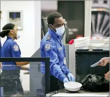  ?? THE ASSOCIATED PRESS ?? TSA officers wear protective masks at a security screening area at Seattle-Tacoma Internatio­nal Airport in SeaTac, Wash. A highrankin­g Transporta­tion Security Administra­tion official says the agency is falling short when it comes to protecting airport screeners and the public from the new coronaviru­s, according to published reports.