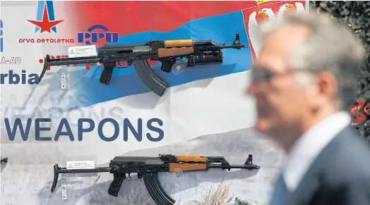  ??  ?? COMPACT: Right, a visitor looks at assault rifles made by the Serbian company Zastava Arms during a defence fair in Belgrade, Serbia. WEAPONS OF CHOICE: Below, rifles on display in the exhibition hall of the Zastava Arms factory in Serbia. Guns like...