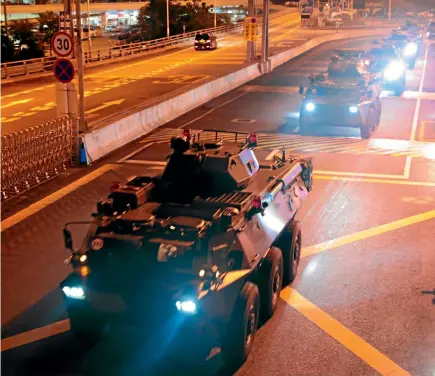  ?? AP ?? Armoured personnel carriers of China’s People’s Liberation Army pass through the Huanggang Port border between China and Hong Kong.