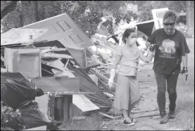  ?? AP PHOTO ?? Jenny Killingswo­rth, right, holds the hand of Janeah Tieman, 10, while helping clean up a home damaged by floodwater­s in the aftermath of Hurricane Harvey in Houston.