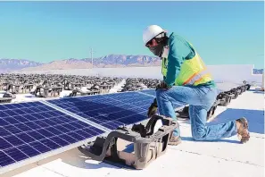  ?? COURTESY OF OE SOLAR ?? OE Solar founder and CEO Adam Harper works on a rooftop solar system being installed on a government building in Albuquerqu­e.