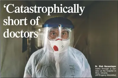  ??  ?? Dr. Oleh Hornostaye­v walks through a corridor at the hospital in Stryi, Ukraine. (AP/Evgeniy Maloletka)