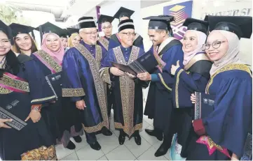  ??  ?? Ahmadshah (centre) and on his right, Prof Dato Dr Jamil Jamali engage with recipients of the Vice-Chancellor Award.