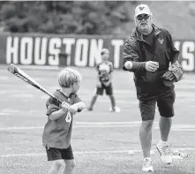  ?? Brett Coomer / Staff photograph­er ?? Texans chief operating officer Cal McNair makes a pitch to his son Calhoun as they play on the practice field Wednesday.