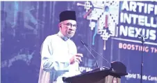  ?? ?? Anwar delivers his opening address during the launching of MY AI NEXUS 2024.